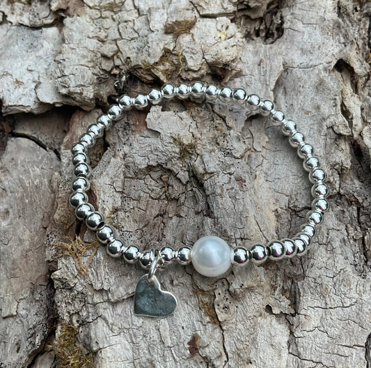 Ein 925  Silber Perlenarmband mit einer Perle und einem Herzanhänger.