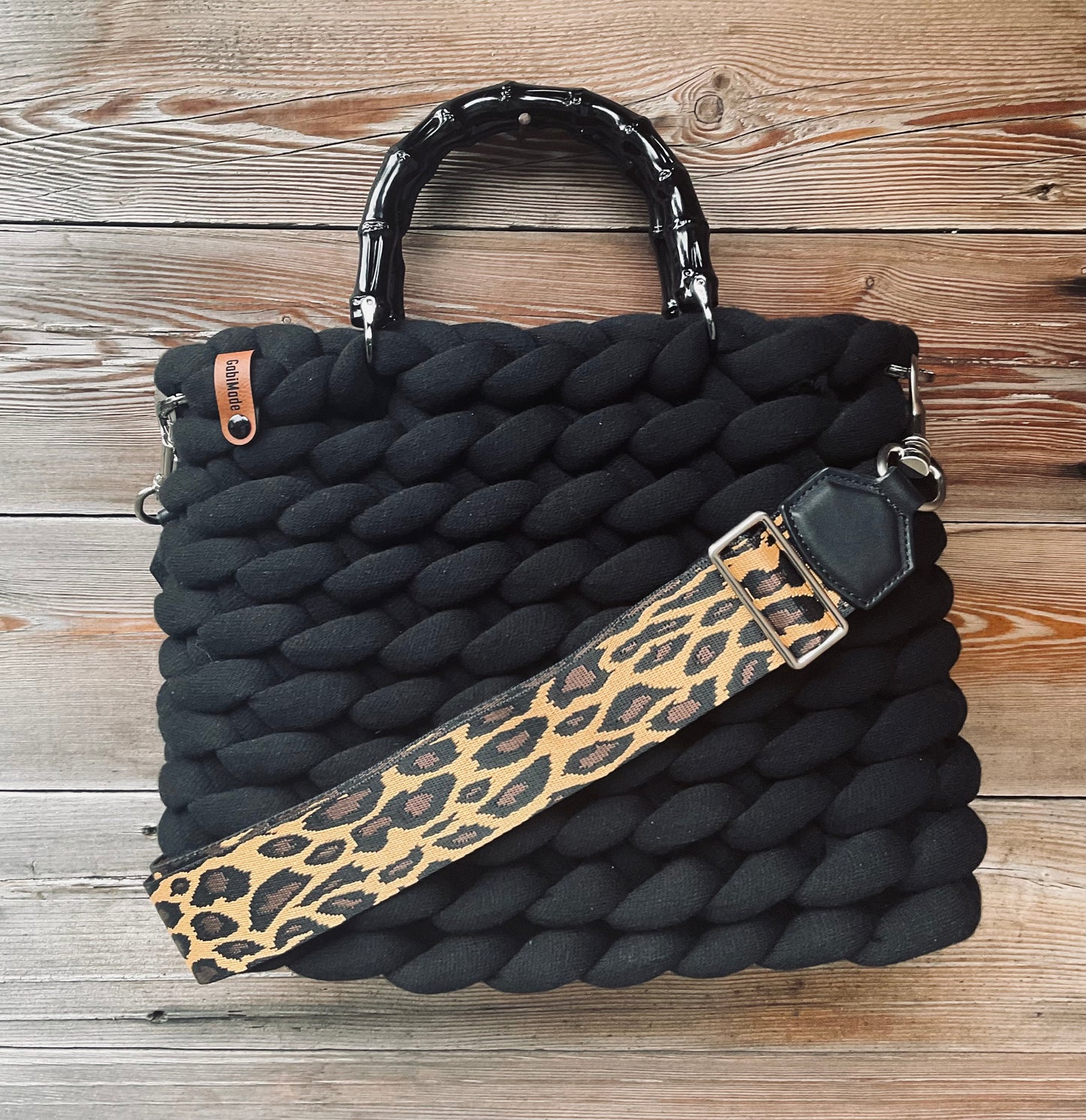 Eine gestrickte schwarze Tasche mit bambusgriffen