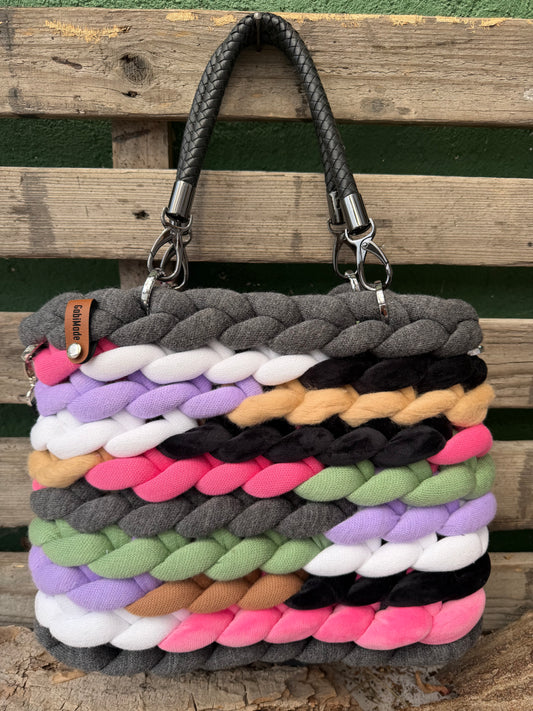 Eine bunte gestrickte Tasche mit Kunstleder Griffen 