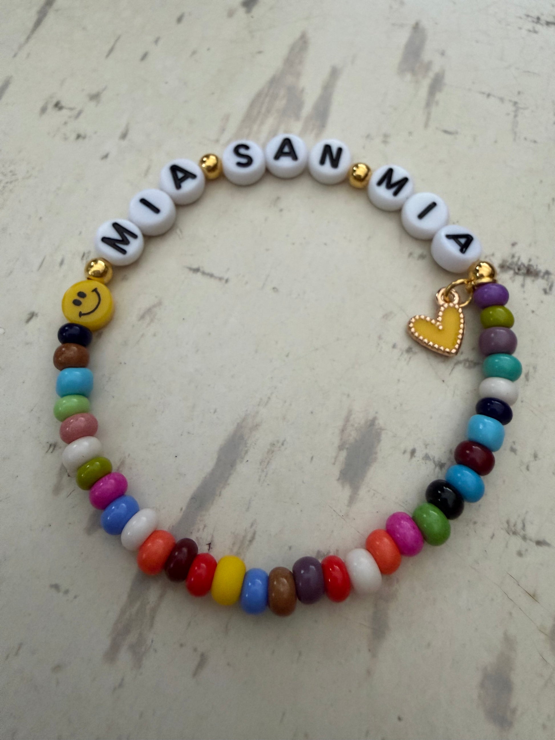 Ein buntes Perlenarmband mit Smiley und Mia san Mia 