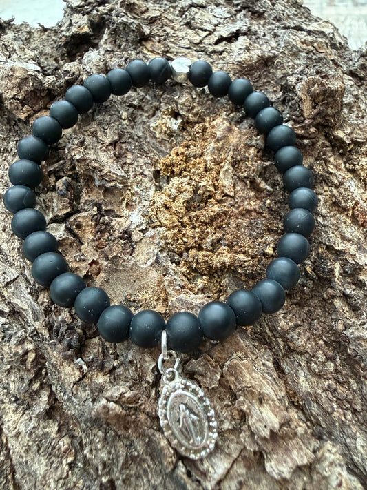 Ein schwarzes Perlenarmband mit Herz und Madonnen Anhänger 