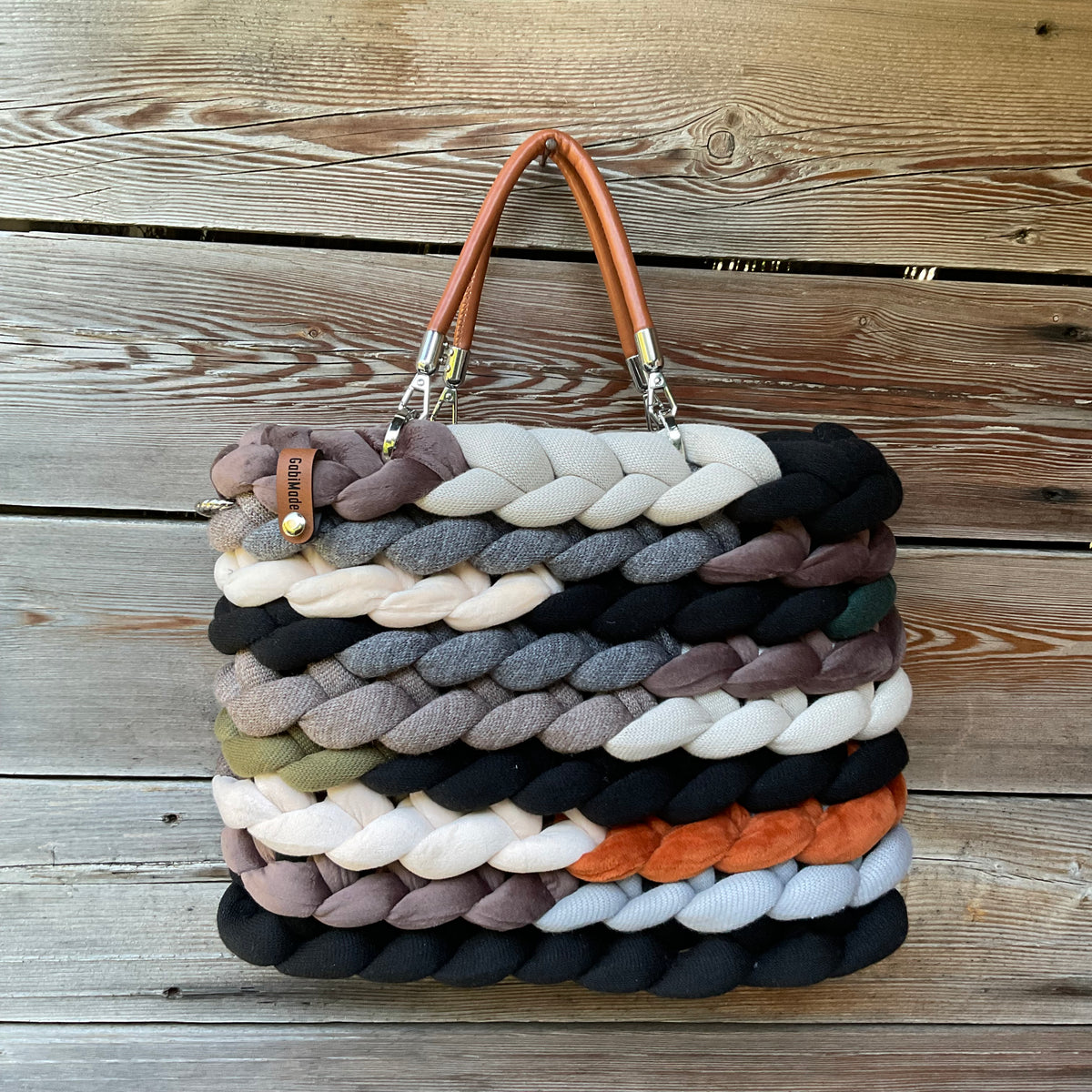 Eine gestrickte Tasche in Brauntönen mit griffen