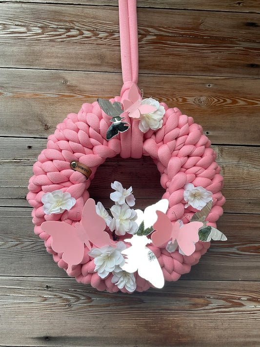 Ein gestrickter rosa Kranz mit Dekor 