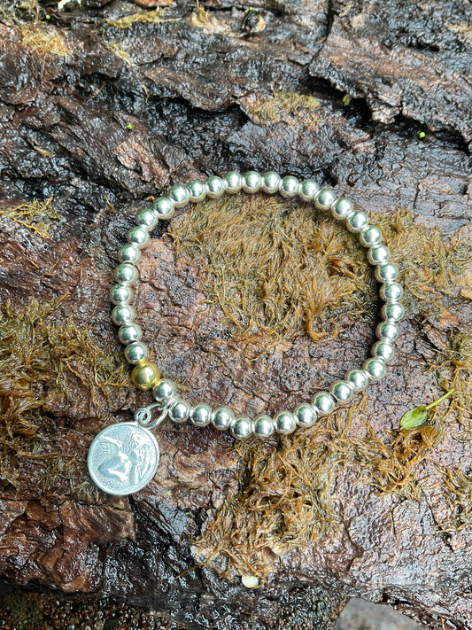 Ein 925 Silber Perlenarmband mit einer vergoldeten Perle und einem Schutzengel Anhänger.