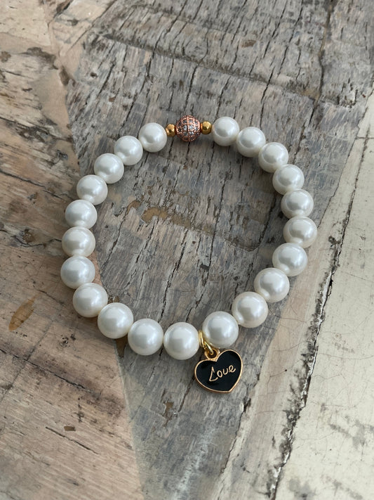 Ein Perlenarmband mit einem Herzanhänger 