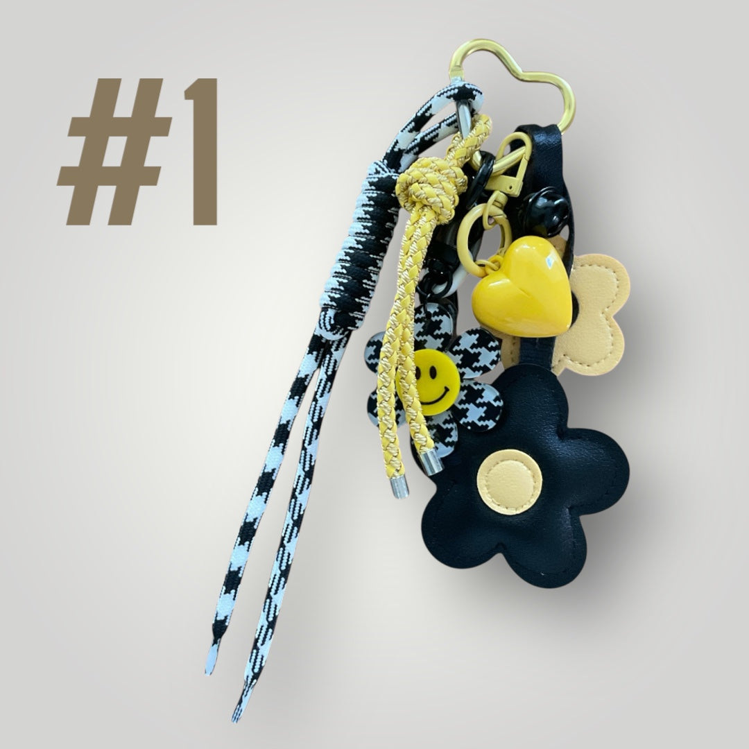Ein schwarz und gelber Taschenanhänger mit einer Blume und einem Herz