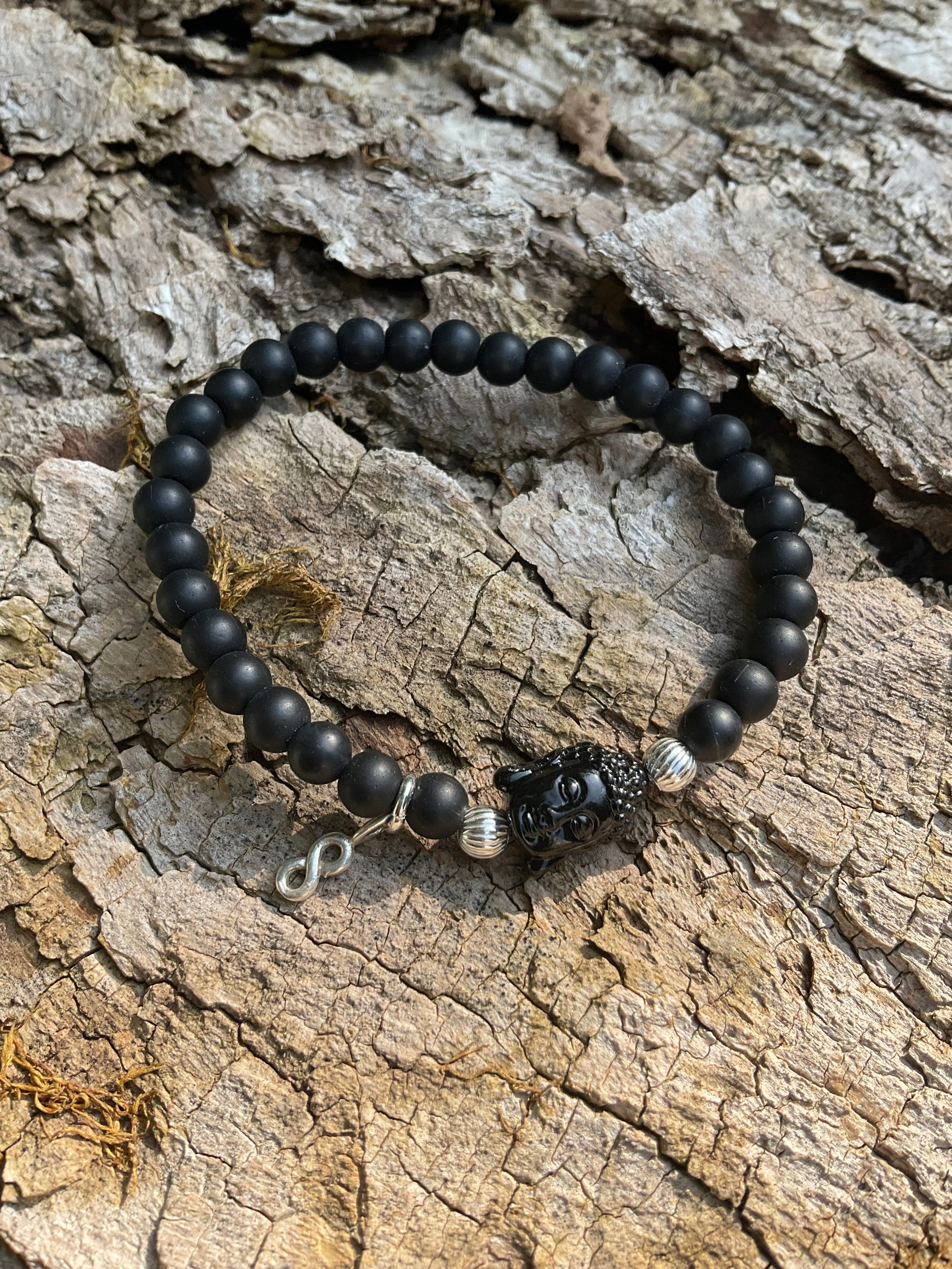 Ein schwarzes Perlenarmband mit Buddha und Anhänger 