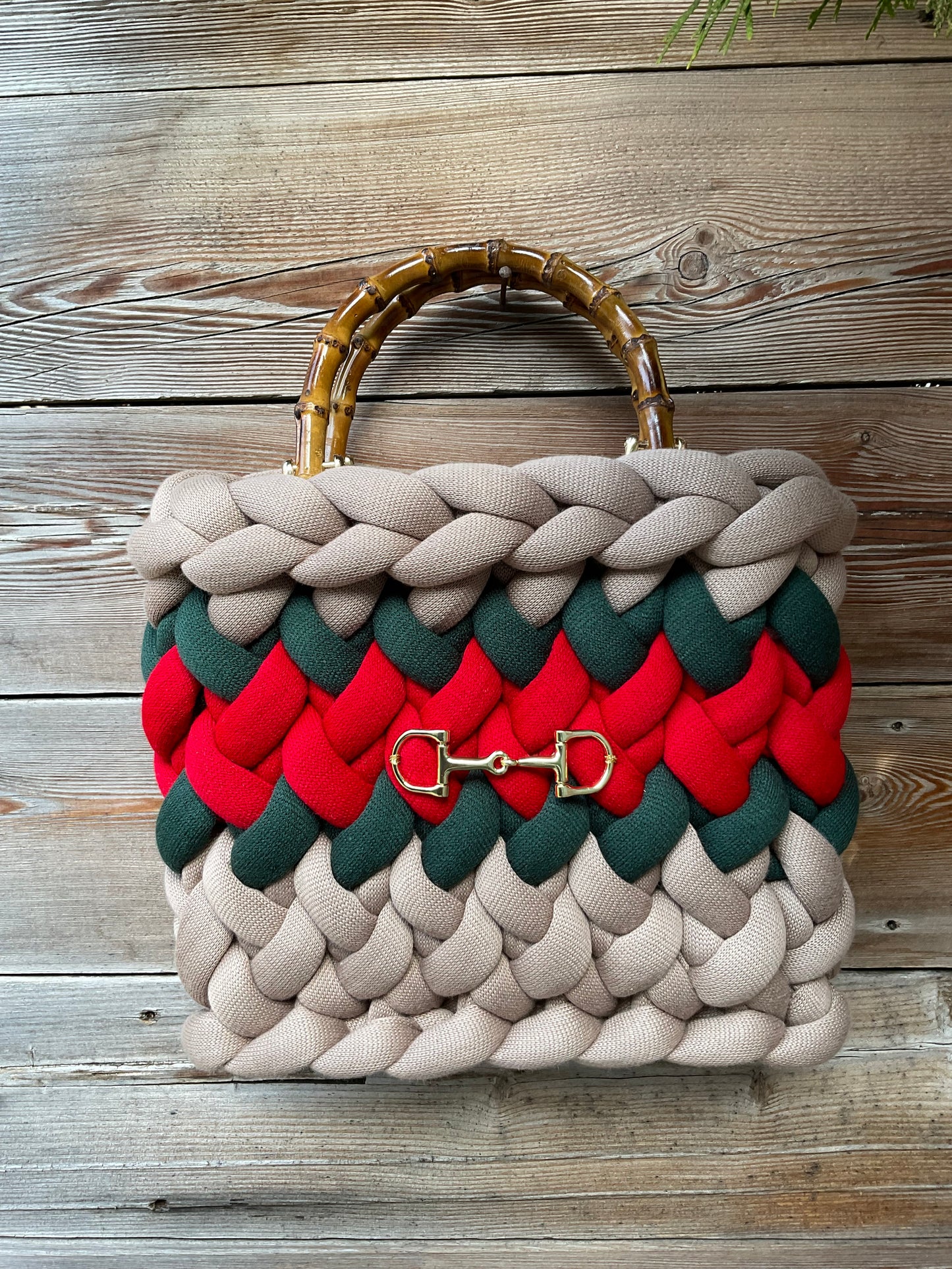 Eine gestrickte Tasche mit Streifen und Bambusgriffen 