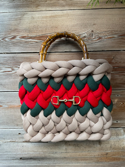 Eine gestrickte Tasche mit Streifen und Bambusgriffen 
