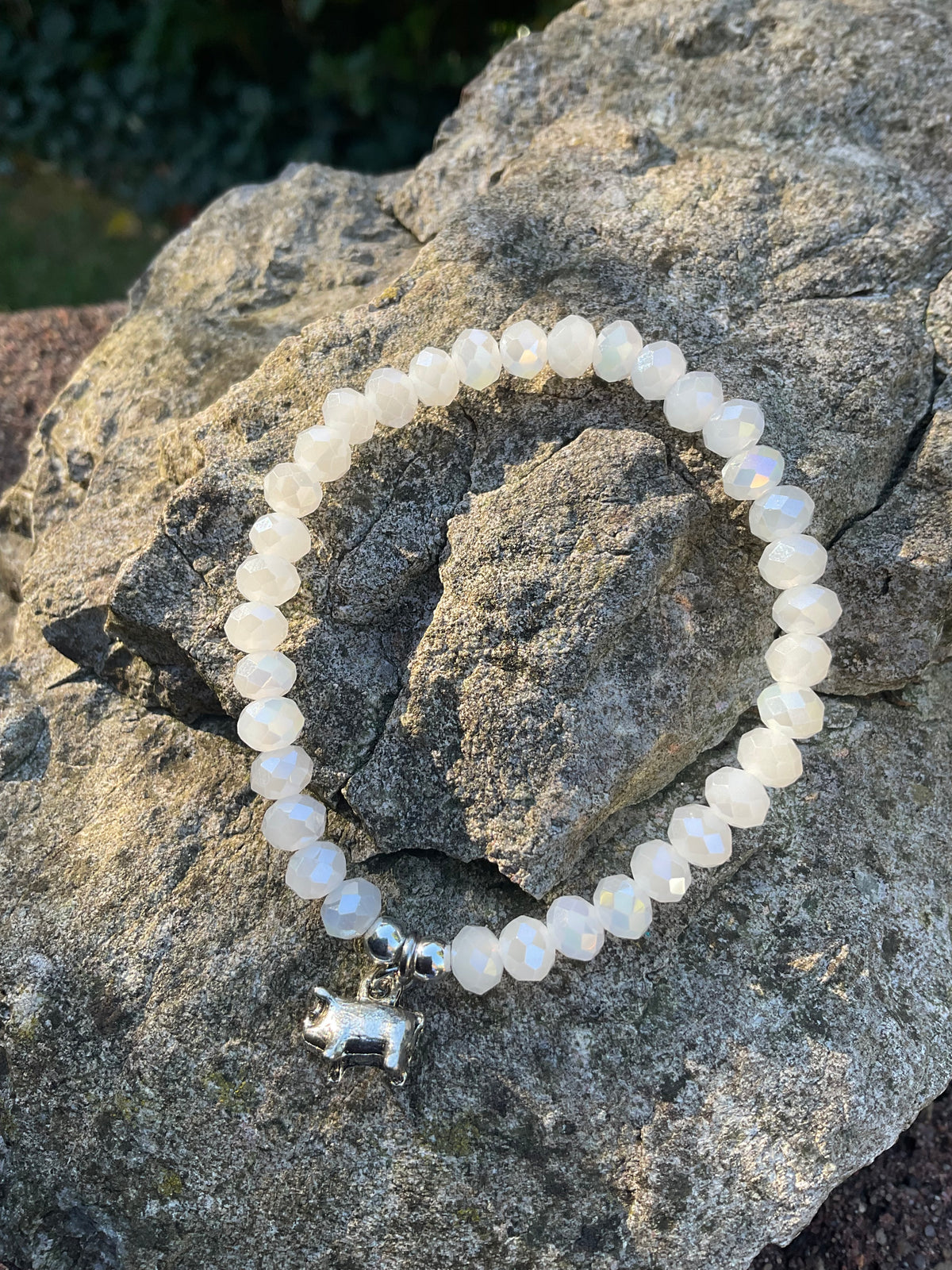 Ein weißes Armband mit Schweinchen anh