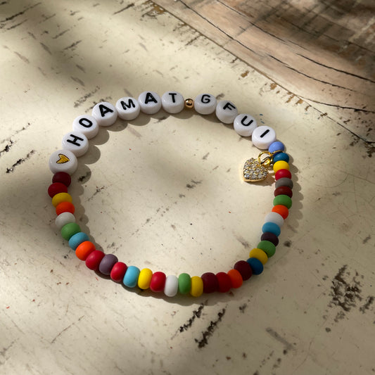 Ein buntes Perlenarmband mit glitzerndem Herzanhänger 