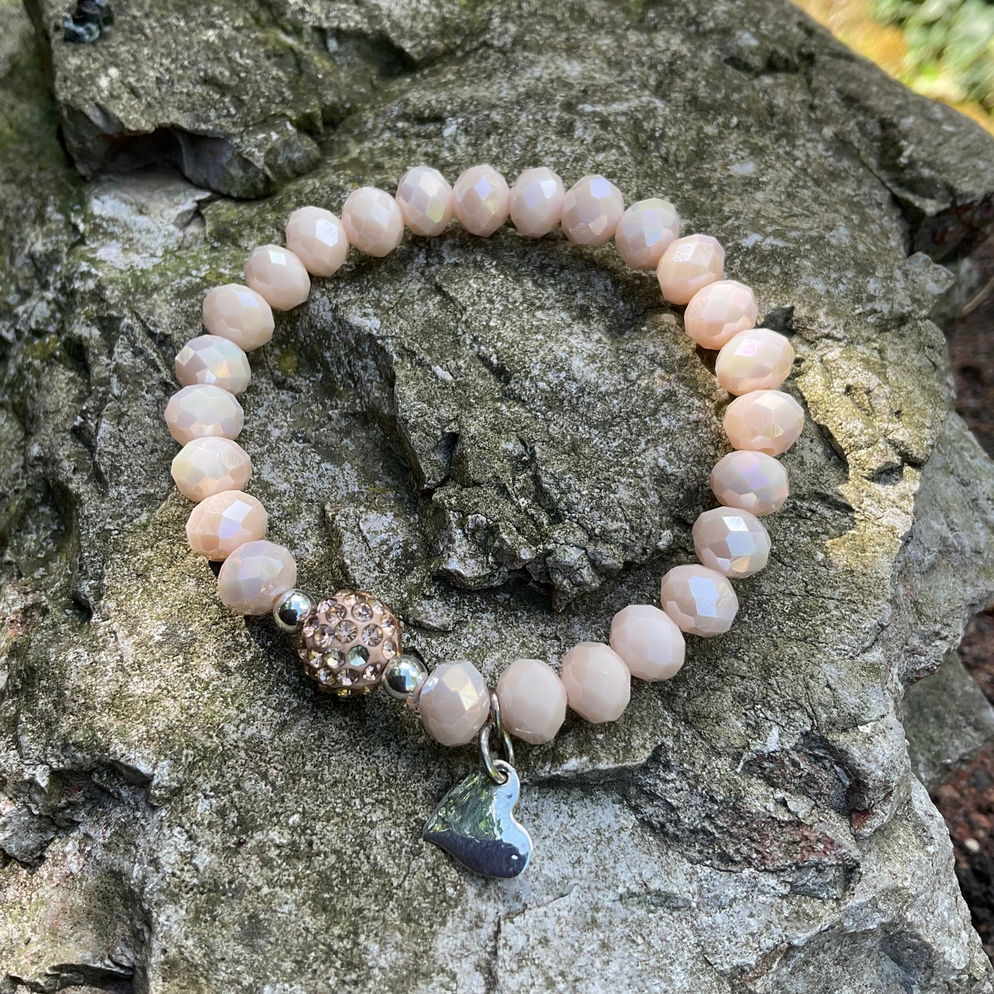 Ein cremefarbenes Perlenarmband mit strßperle und Herzanhänger 