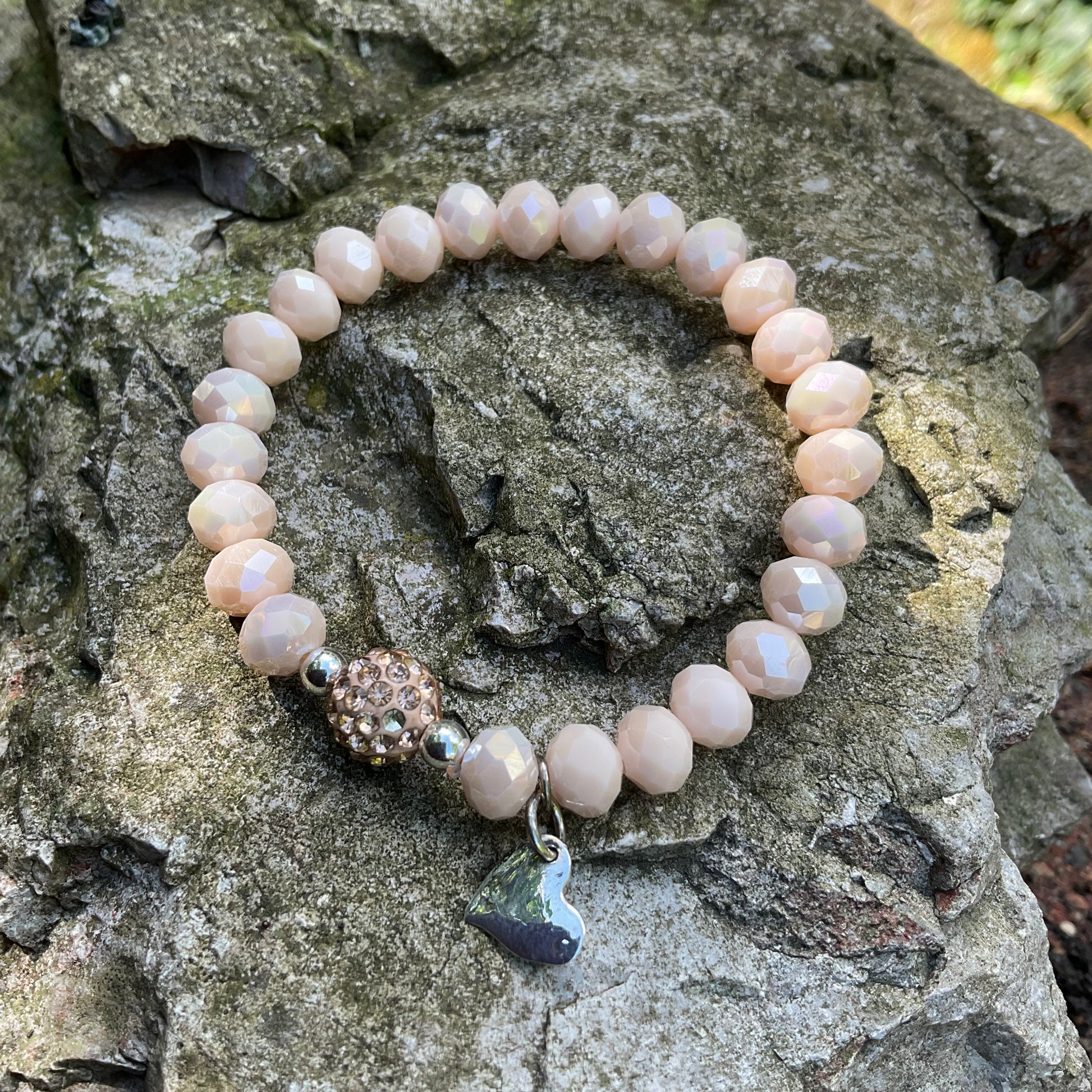 Ein cremefarbenes Perlenarmband mit strßperle und Herzanhänger 