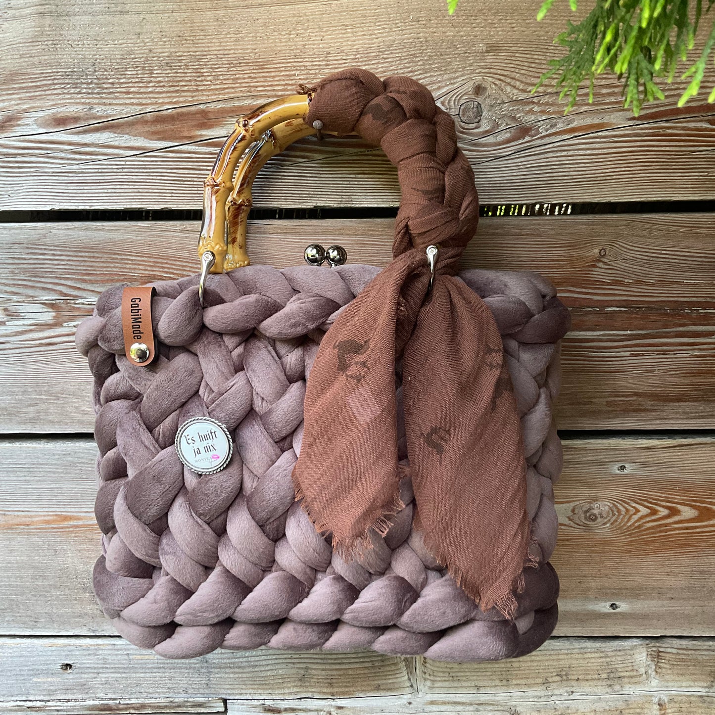 Eine braune Trachtentasche mit Tuch und Gaudiknopf 