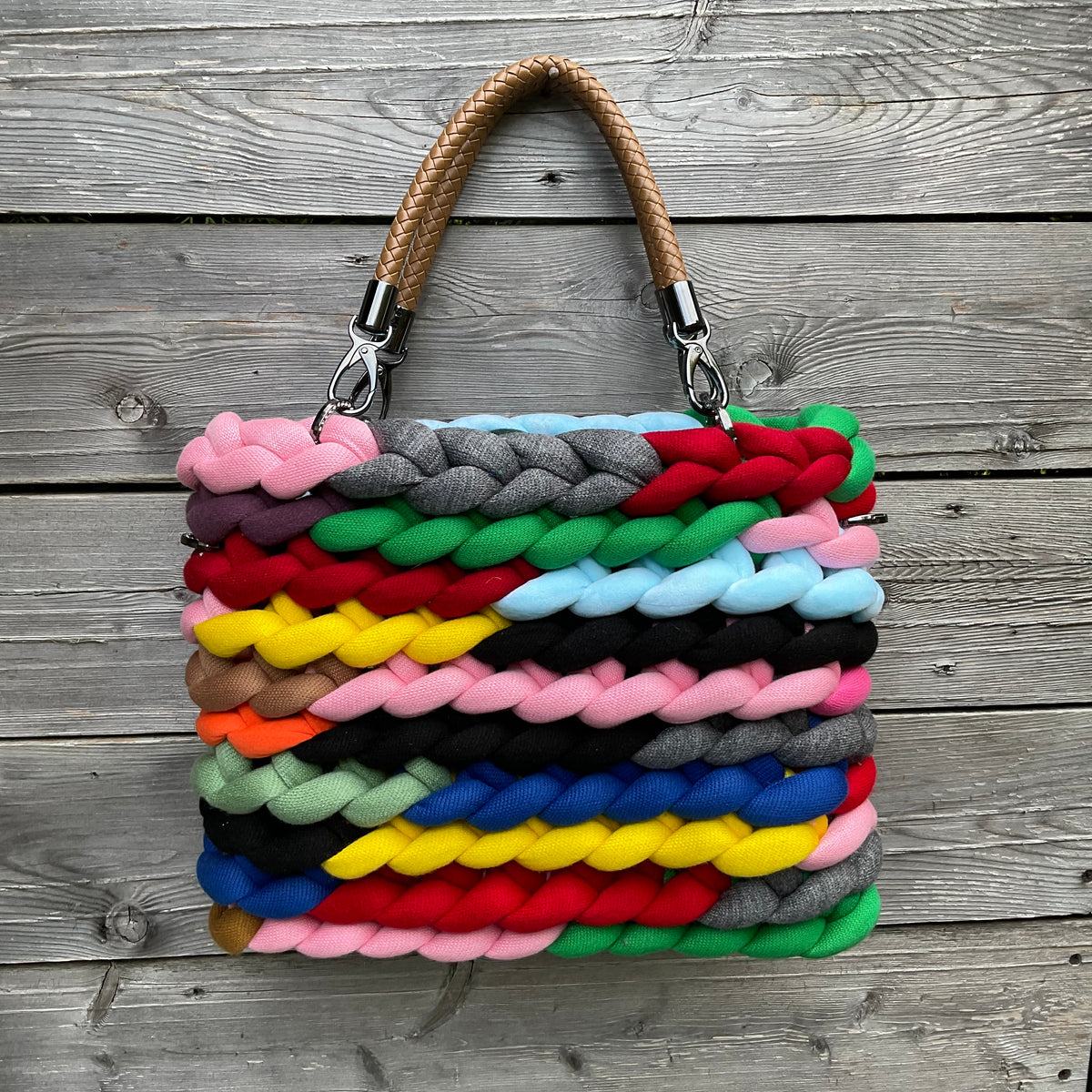 Eine bunte gestrickte Tasche mit Kunstleder Griffen 