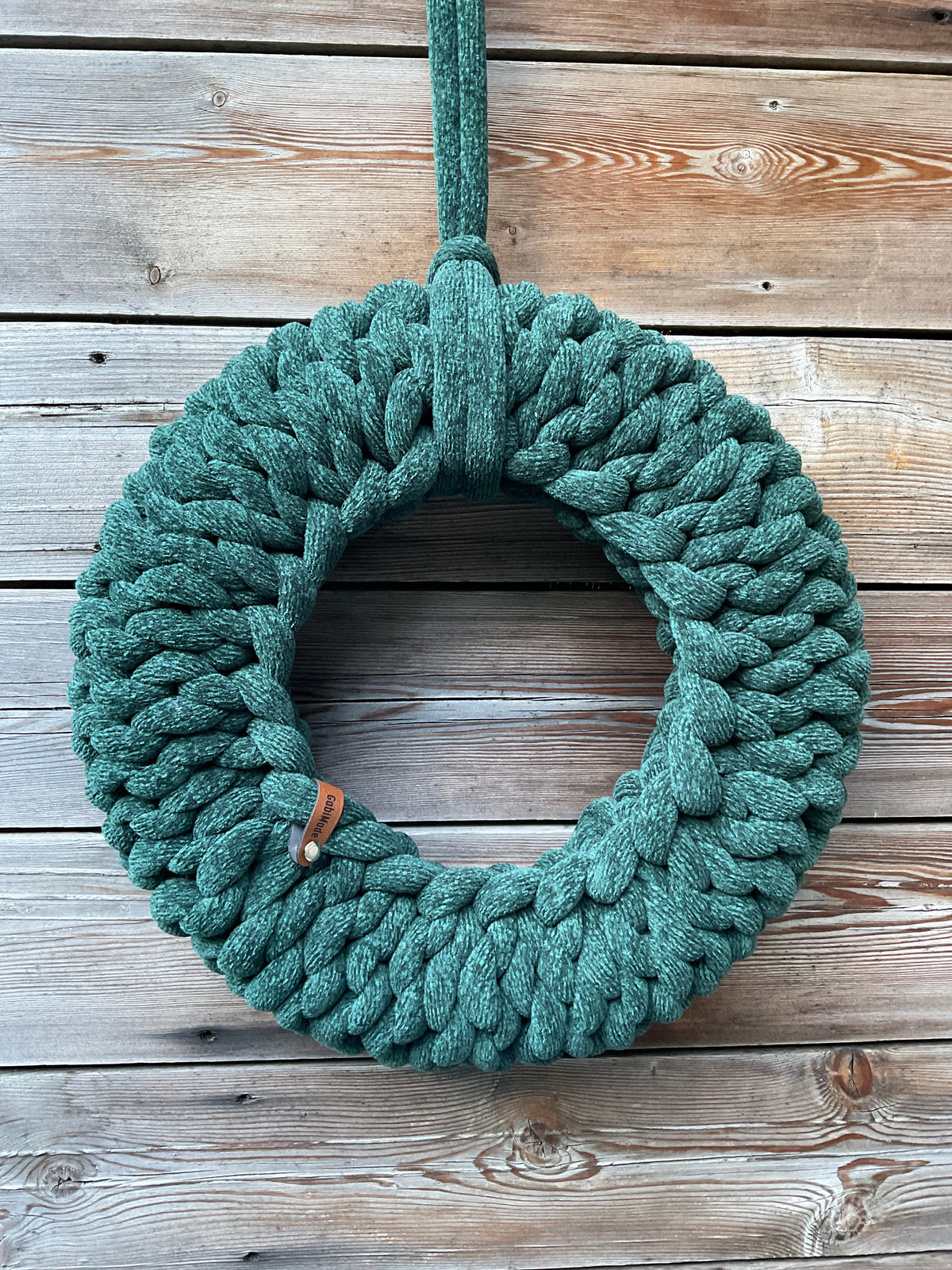 Ein grüner gestrickter Kranz in Größe M