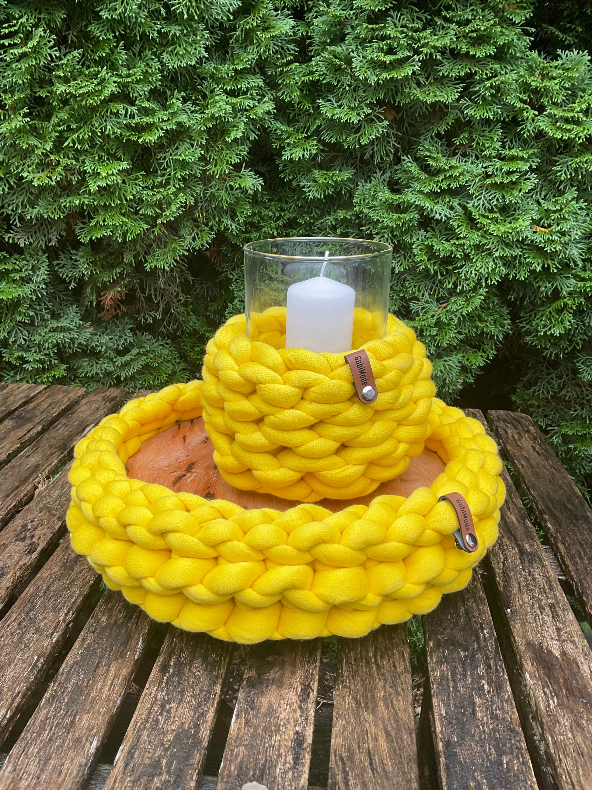 Ein gestricktes gelbes Tablett mit Holzplatte 