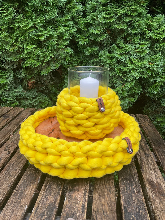 Ein gestricktes gelbes Tablett mit Holzplatte 