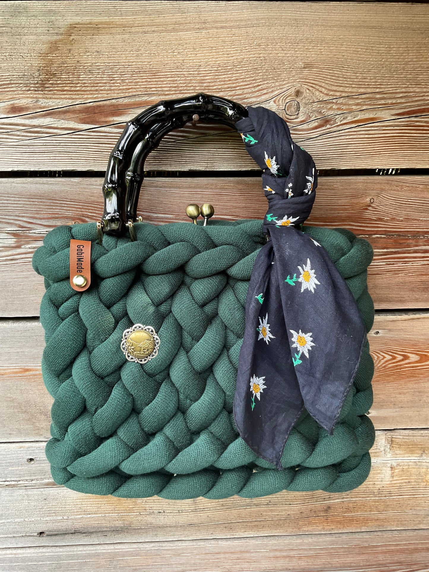 Eine grüne gestrickte Trachtentasche mit Tuch und Bambusgriffen 