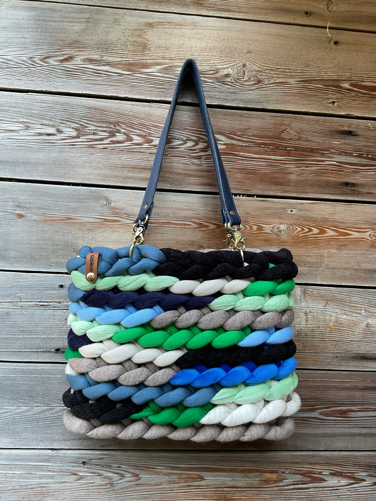 Eine gestickte Tasche in Blautönen mit Riemen 