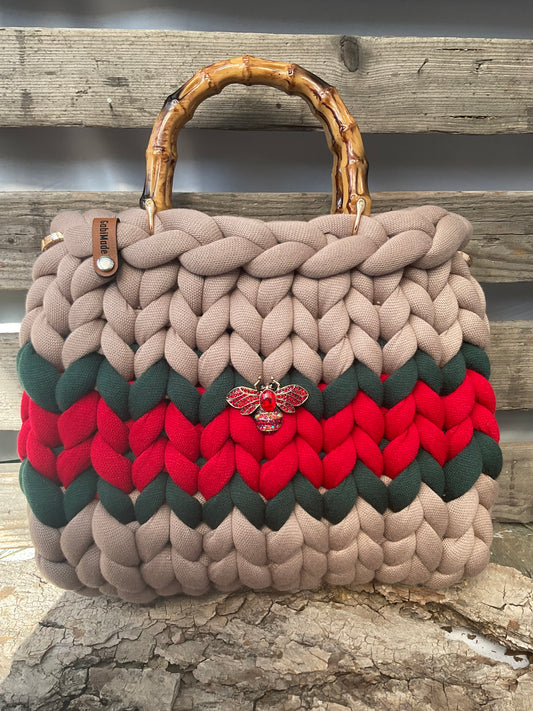 Eine gestrickte Tasche mit Streifen und Brosche 