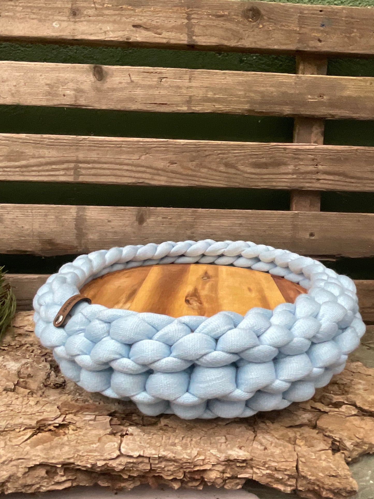 Ein gestricktes Tablett mit Holzteller 