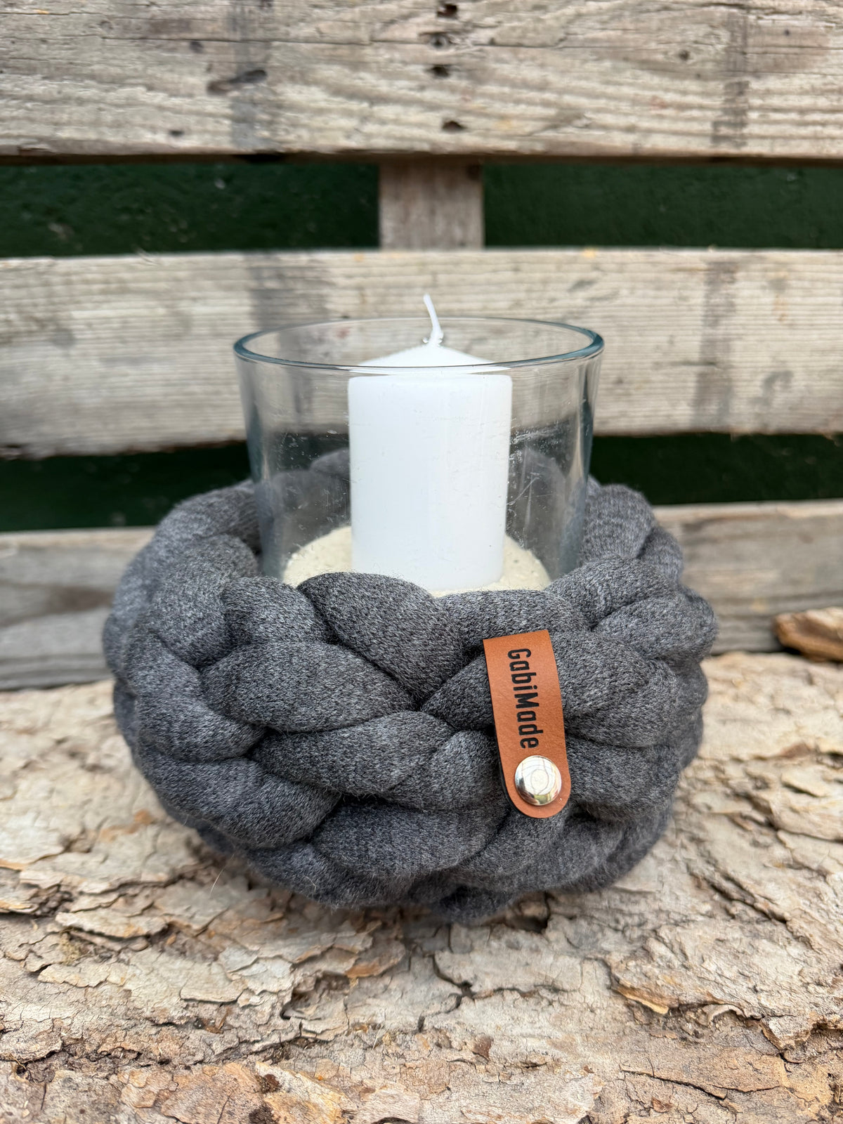 Ein gestricktes anthrazitfarbenes Windlicht mit Glaseinsatz 