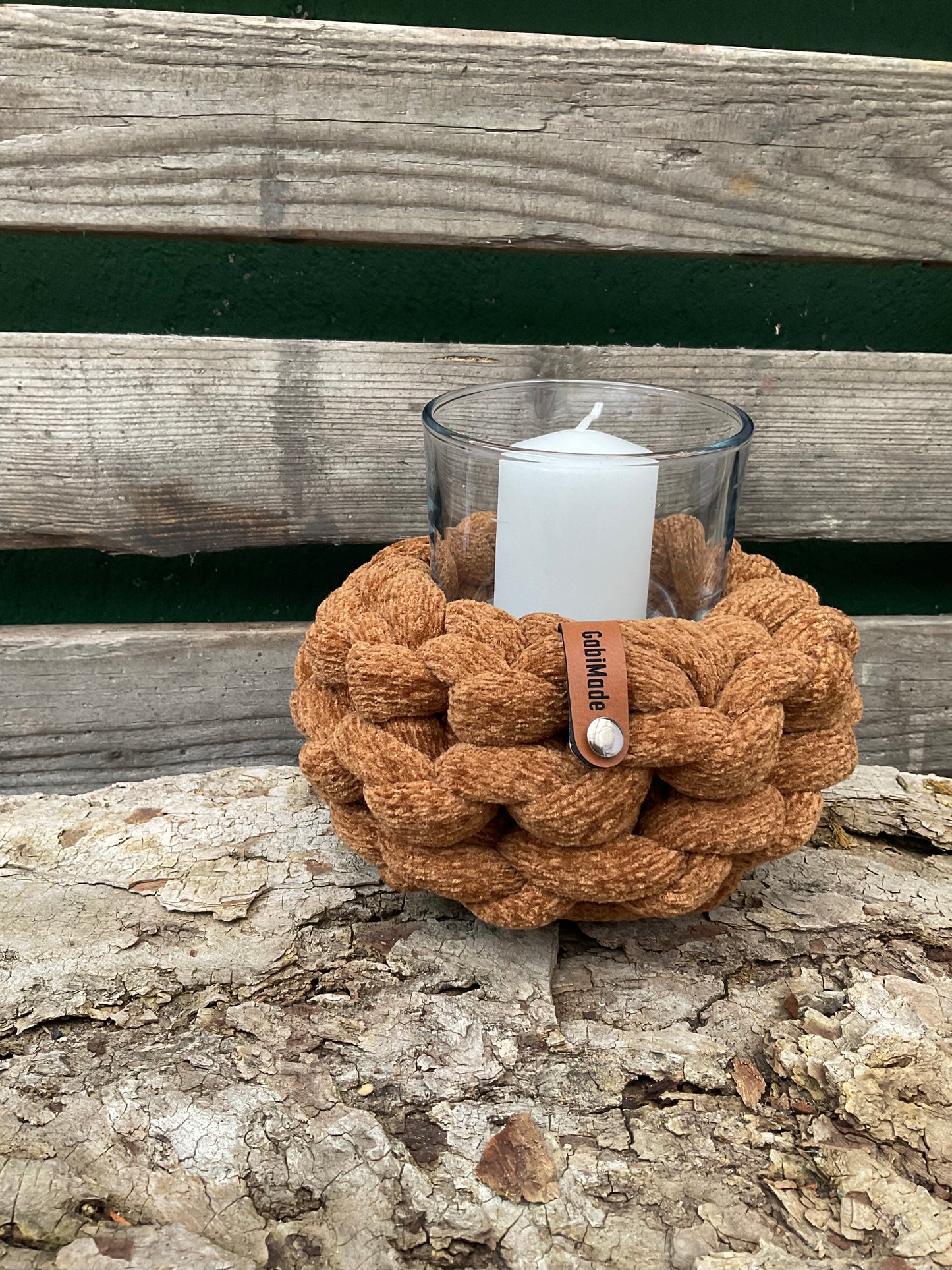 Ein gestricktes braunes Windlicht mit Glaszylinder 
