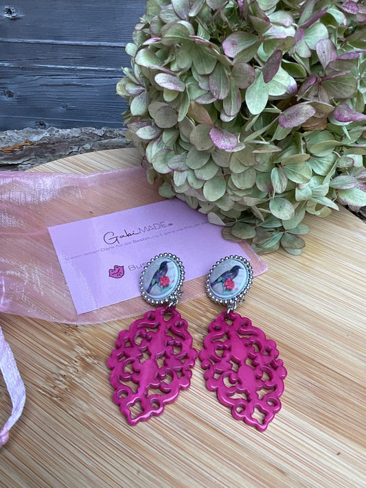 Ohrring aus pinken Anhänger und glitzernden vogelmotiv