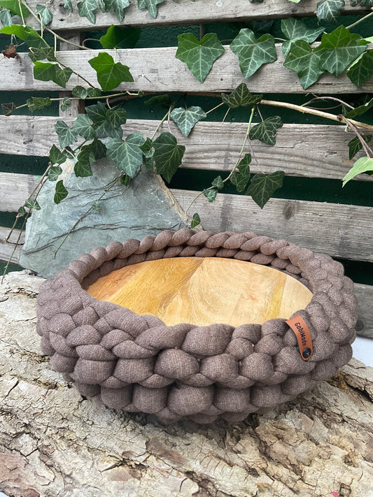 Ein getricktes braunes Tablett mit Holzteller 