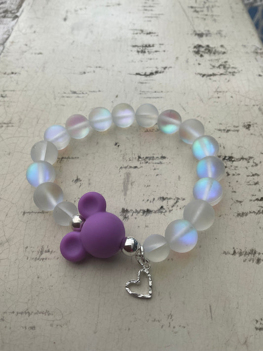 Ein schimmerndes Perlenarmband mit lila MausiKopf