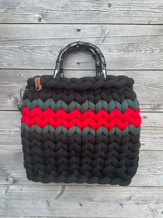 Eine gestrickte schwarze Tasche mit Streifen 