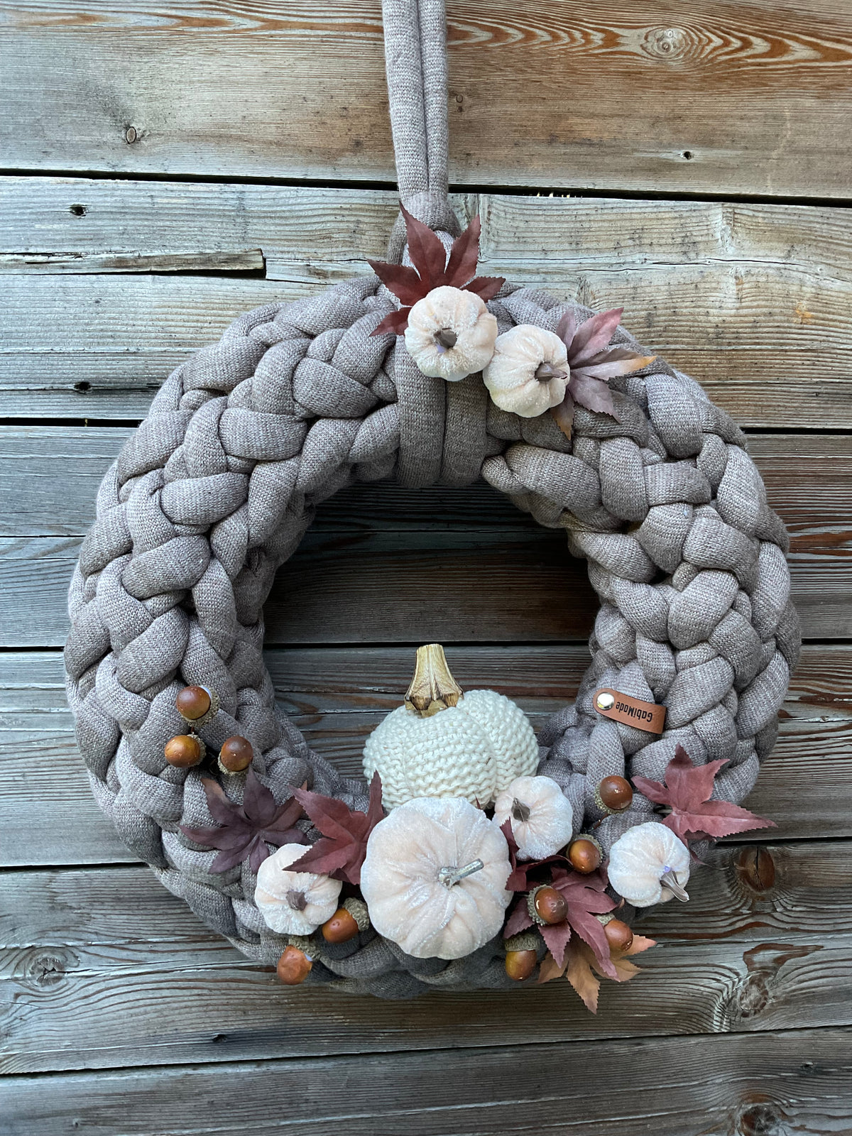Ein gestrickter Kranz herbstlich geschmückt 