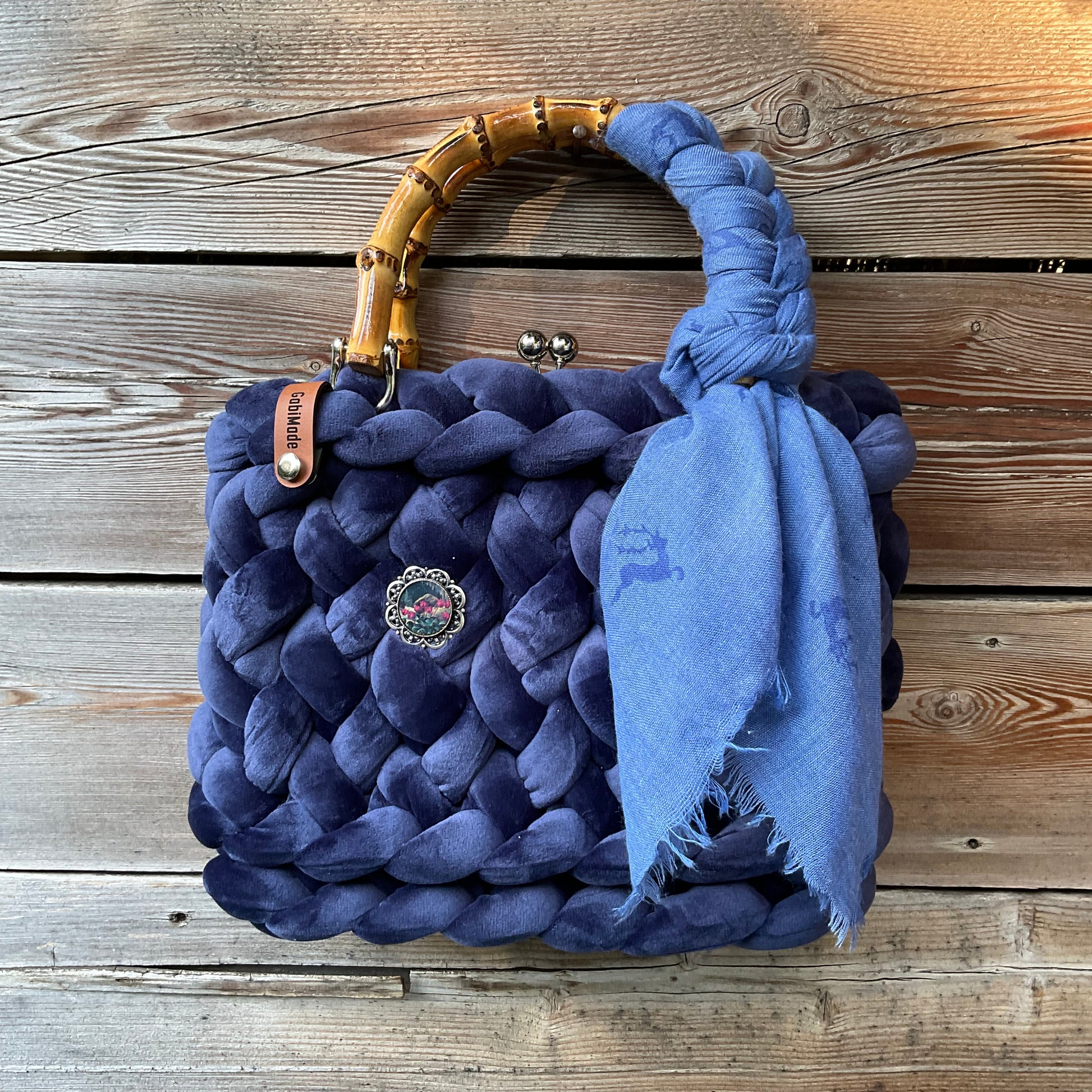 Eine gestrickte dunkelblaue Tasche mit Tuch und nBambusgriffen 