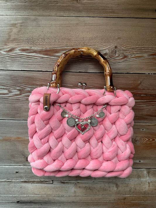 Eine rosa gestrickte Trachtentaschen mit Charivari 