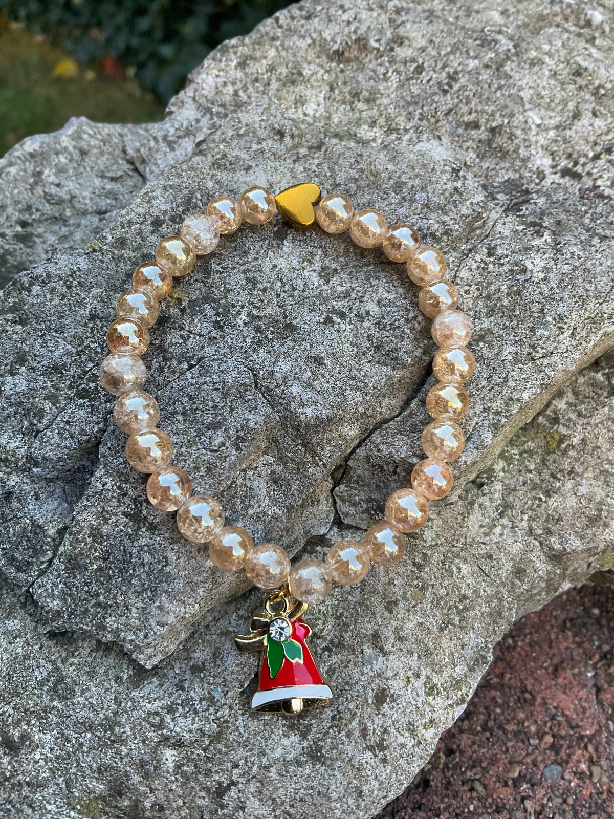 Ein Perlenarmband aus Bergkristall mit einem Glocken Anhänger 