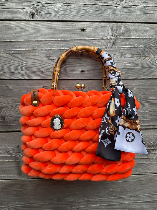 Eine gestrickte orange Trachtentasche