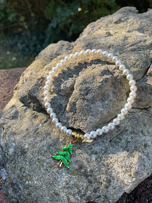 Ein Perlenarmband mit einem Christbaum Anhänger 