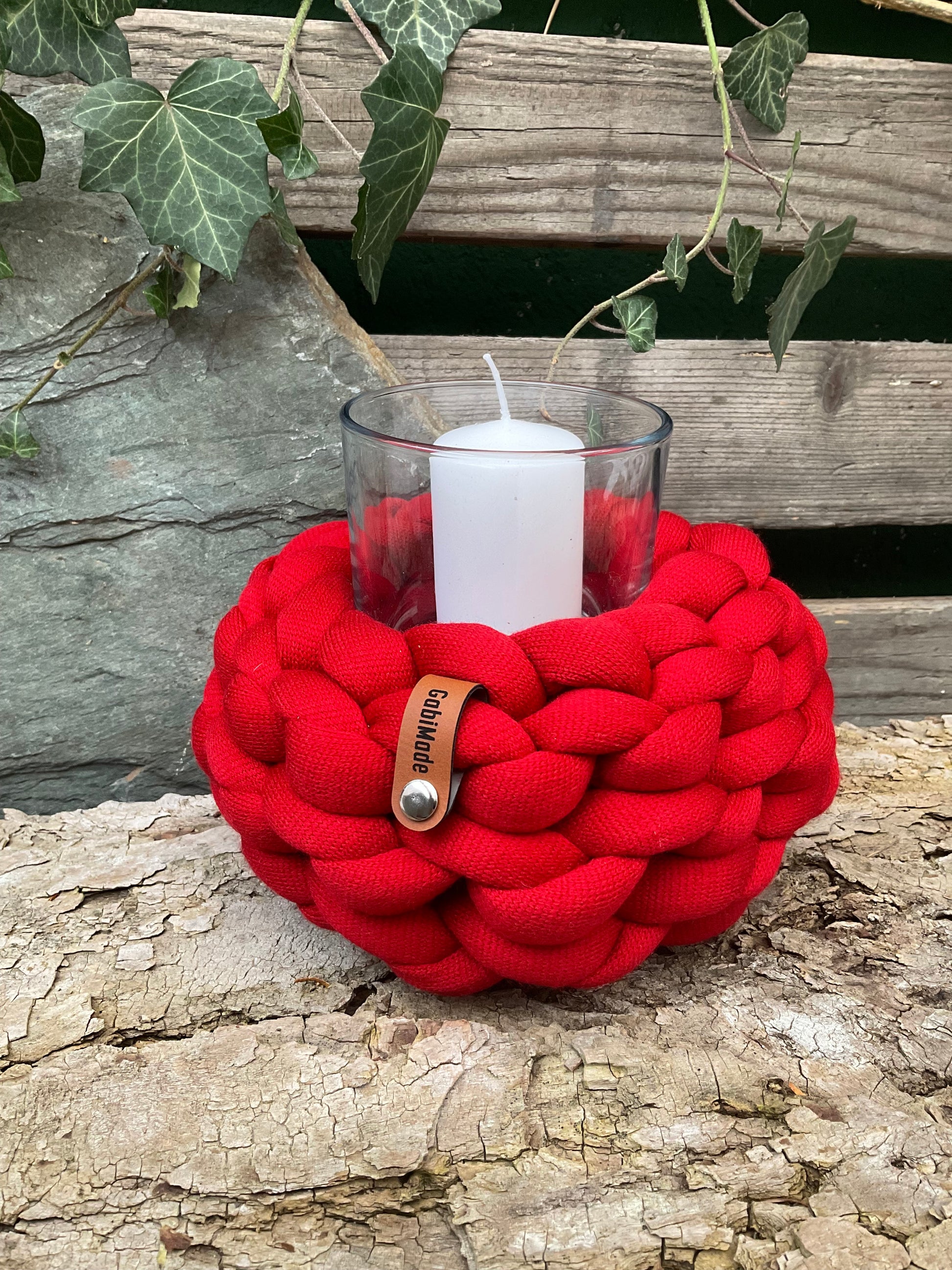 Ein gestricktes rotes Windlicht mit Glaseinsatz 