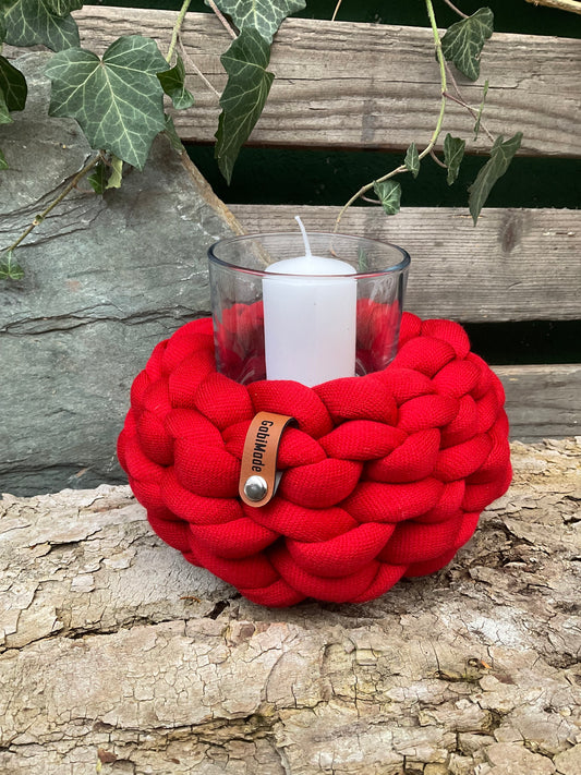 Ein gestricktes rotes Windlicht mit Glaseinsatz 