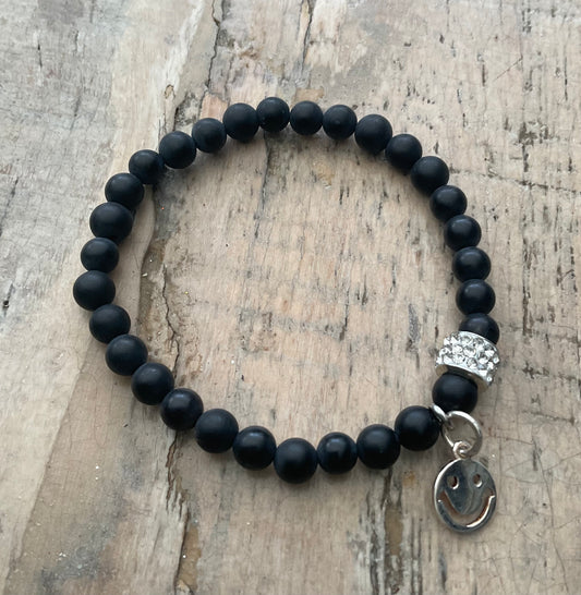 Ein schwarzes perlenarmband mit Smiley Anhänger 