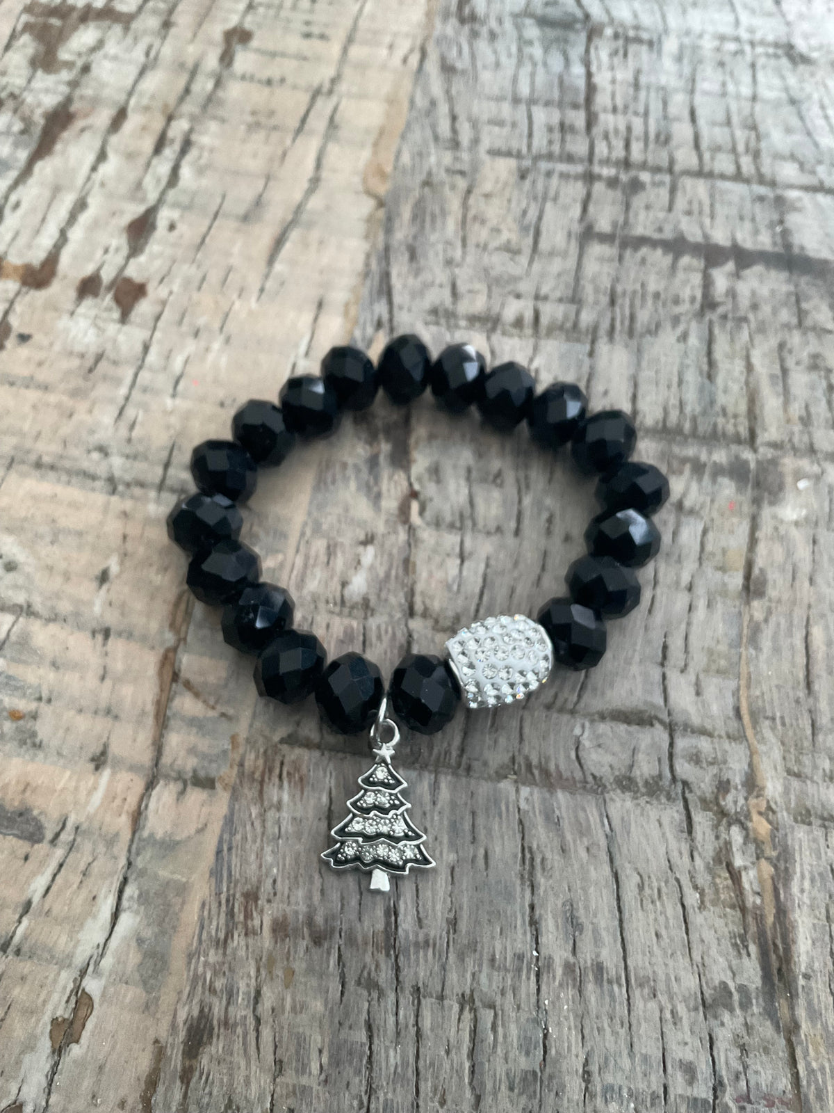 Ein schwarzes Armband mit Tannenbaum Anhänger 