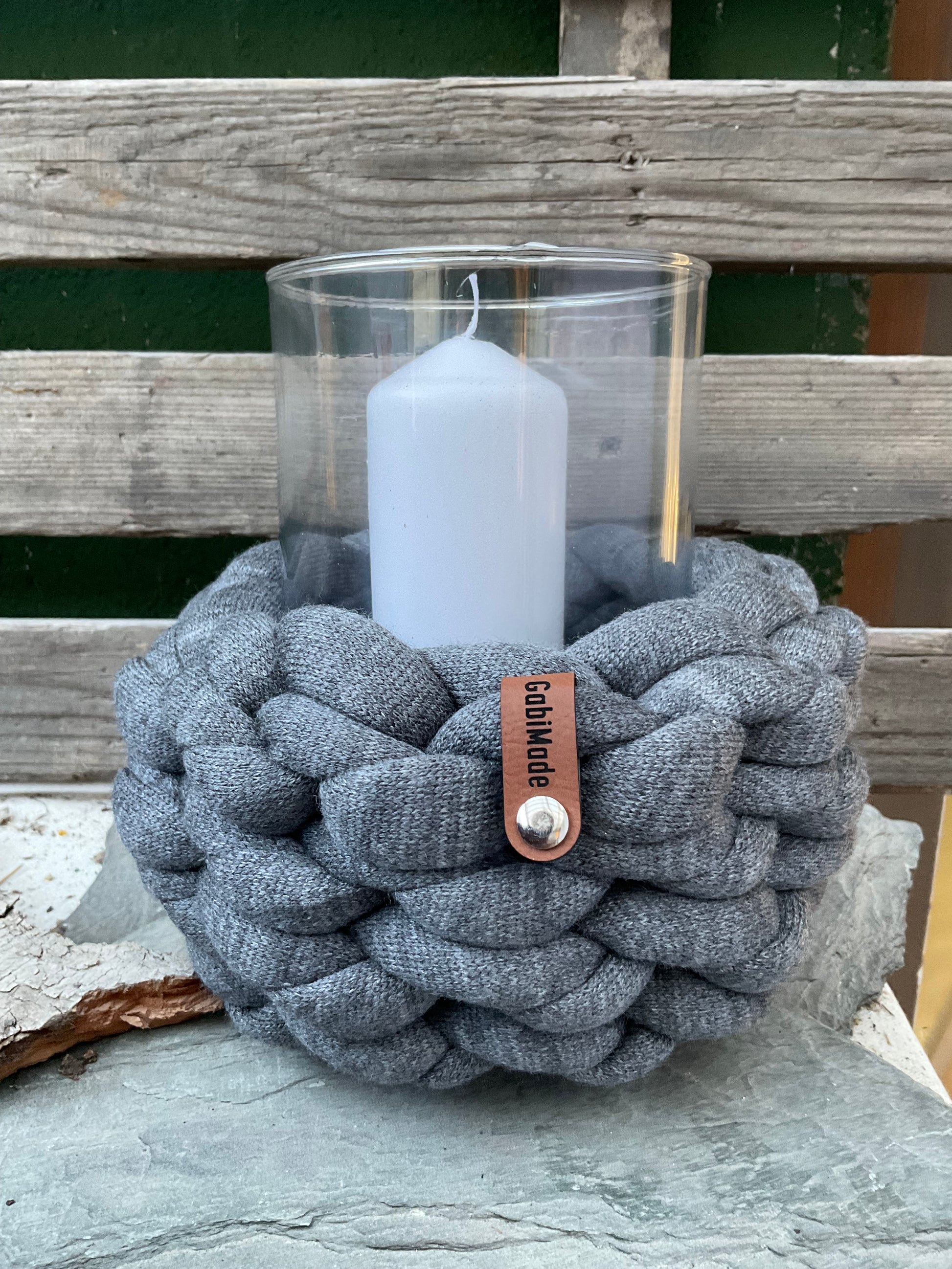 Ein graues Gr. M gestricktes Windlicht mit Glaseinsatz und Kerze 