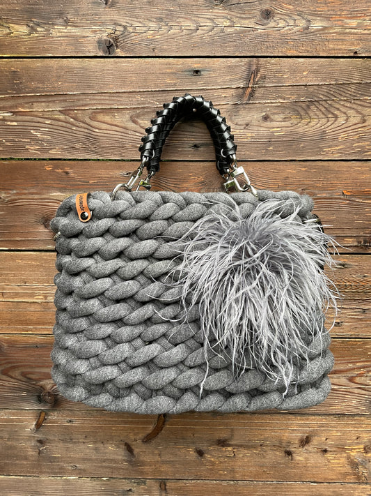 Eine gestrickte schwarze Tasche mit Ledergriffen 