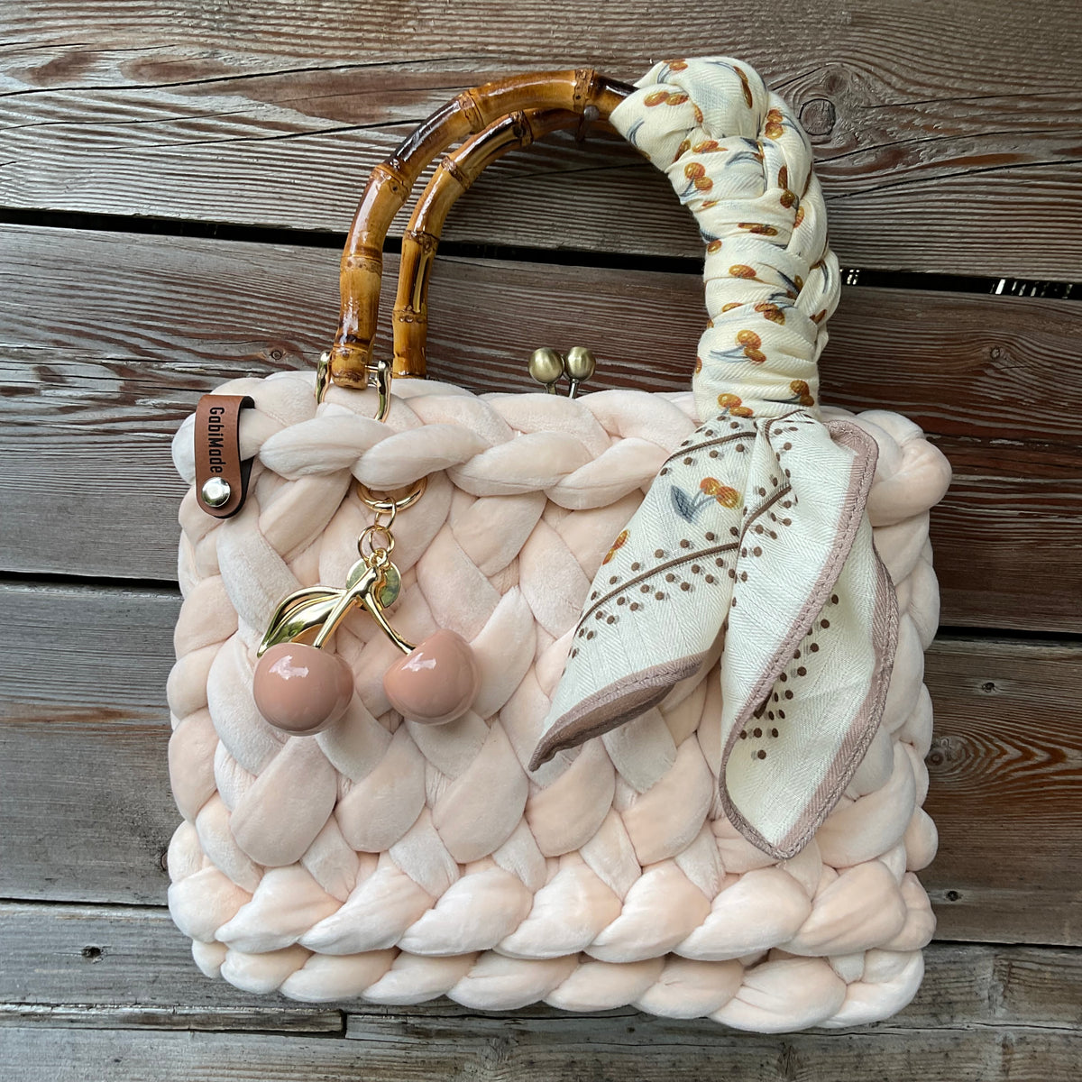 Eine gestrickte cremefarbene Tasche mit Bambusgriffen 