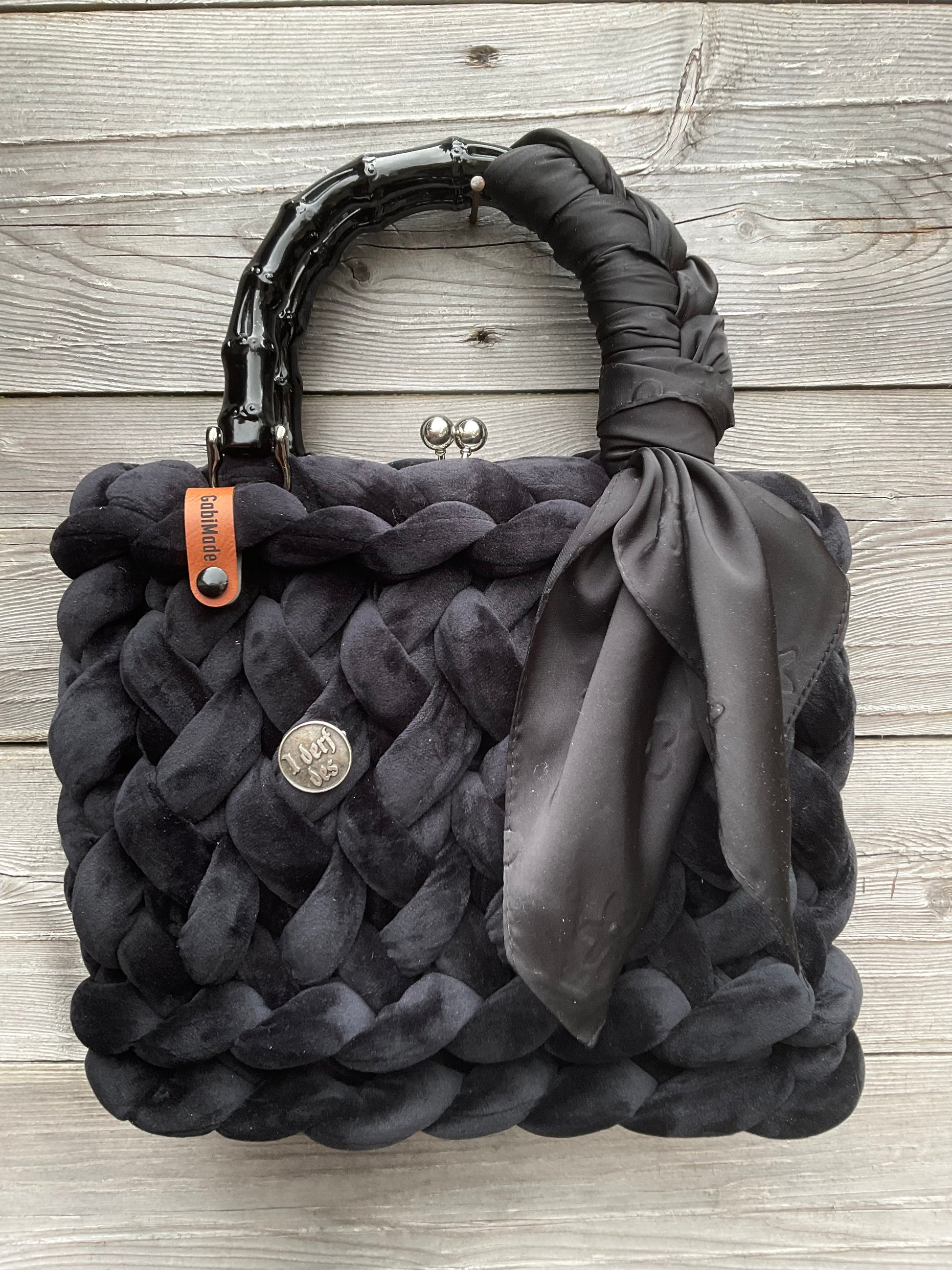 Eine gestrickte schwarze Trachtentasche mit Tuch und Anstecker 