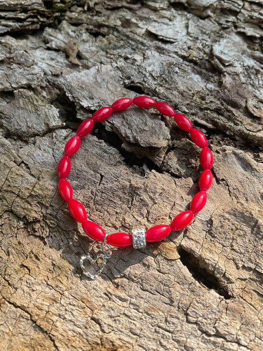 Ein rotes Perlenarmband mit Herz Anhänger 