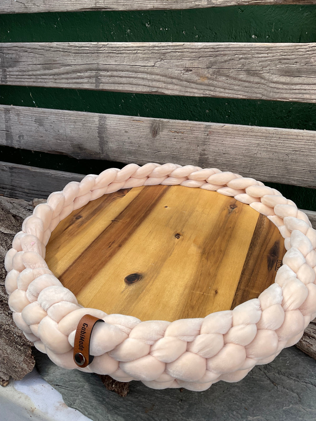 Ein gestricktes Tablett aus Samt mit Holzteller 