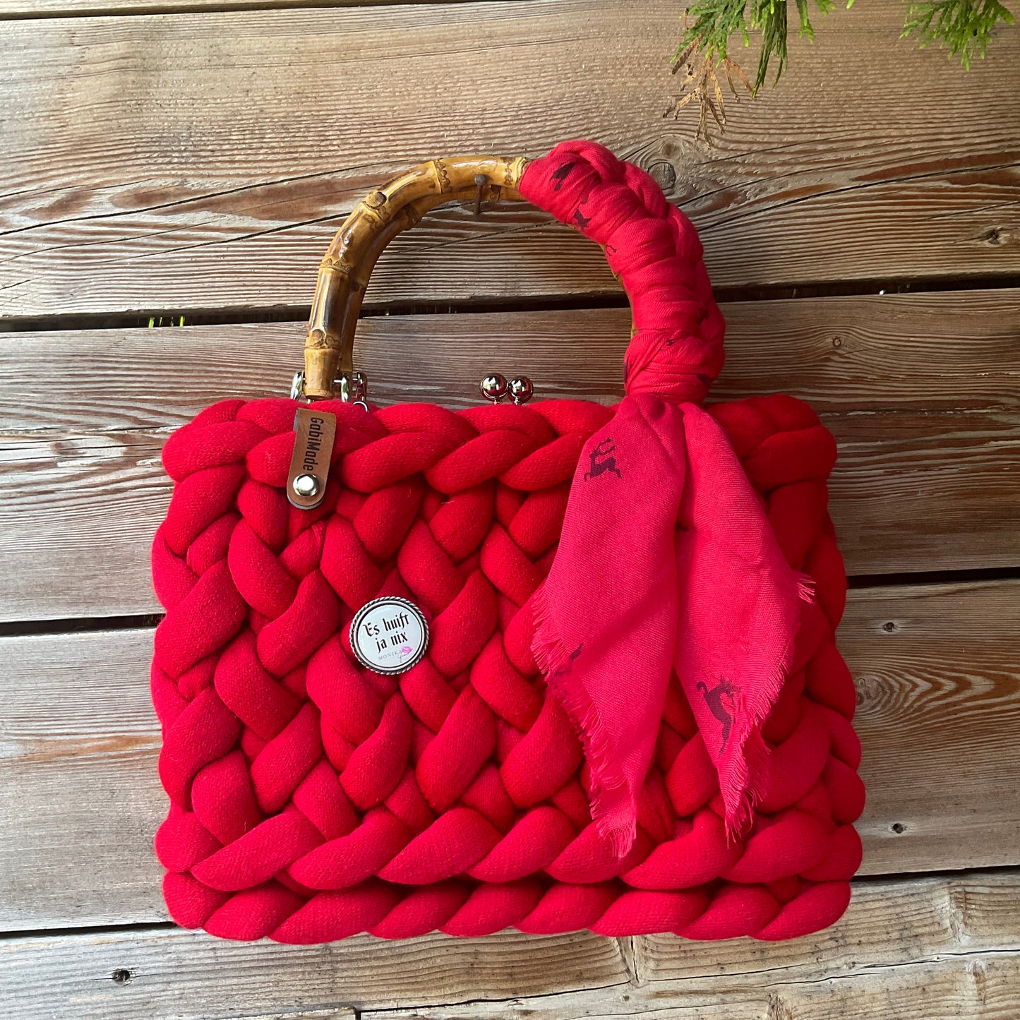 Eine rote Trachtentasche mit Gaudiknopf und Tuch 