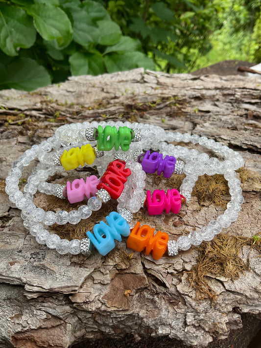 Ein weißes Armband mit dem Wort Love in verschiedenen Farben